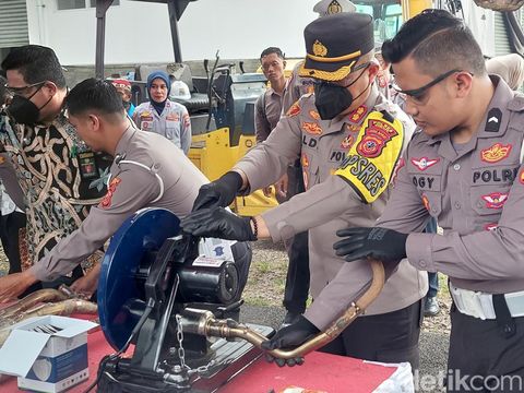 Polisi saat menghancurkan knalpot brong di Polres Cimahi, Kamis (16/3/2023).