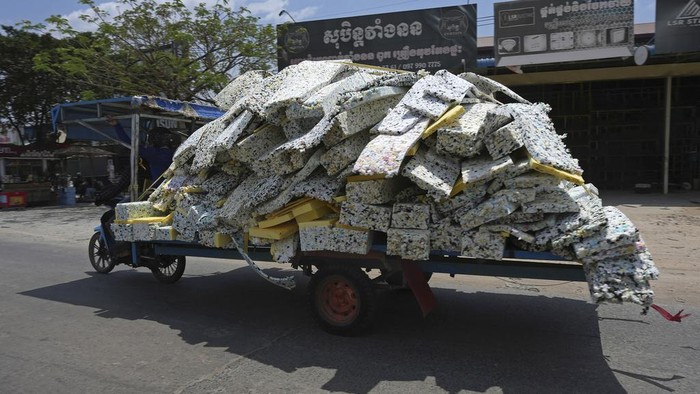 A man on a motor cart carries pieces of rubber is expected to make sofa outside Phnom Penh Cambodia, Thursday, March 16, 2023. (AP Photo/Heng Sinith)