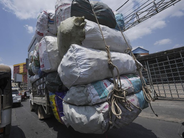 A man on a motor cart carries pieces of rubber is expected to make sofa outside Phnom Penh Cambodia, Thursday, March 16, 2023. (AP Photo/Heng Sinith)