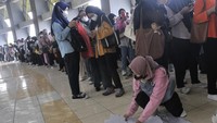 Seorang pencari kerja merapikan berkas pendaftaran sebelum memasuki area Job Fair.