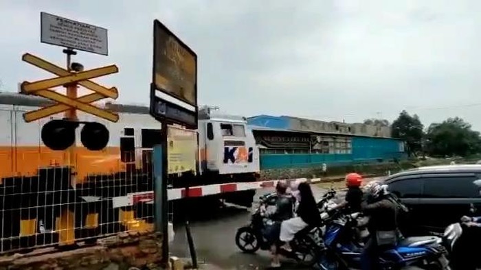 Seorang ibu-ibu bermotor nekat menerobos palang rel kereta api di Cikampek, hingga akhirnya terpeleset dan jatuh dari motor sesaat sebelum kereta lewat.