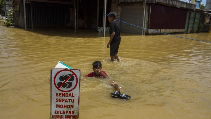 1.340 Rumah Terendam Banjir di Kalimantan Selatan Anak-anak bermain air saat banjir di Barabai, Kabupaten Hulu Sungai Tengah, Kalimantan Selatan, Jumat (17/3/2023). Berdasarkan data BPBD Kabupaten Hulu Sungai Tengah pada Jumat (17/3/2023) sebanyak 4.188 jiwa dan 1.340 rumah di lima Kecamatan terdampak banjir di Kabupaten Hulu Sungai Tengah. ANTARA FOTO/Bayu Pratama S/hp.