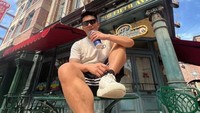 Di kafe Fifth Avenue, New York, Boy William menikmati suasana sambil berfoto. Ia duduk santai dengan segelas bir di tangan.