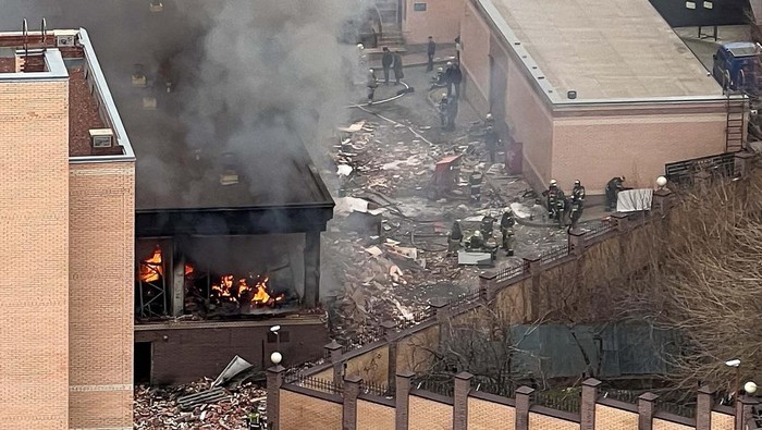 Firefighters and law enforcement officers gather in a street, as smoke from fire caused by an explosion rises near a building belonging to the border patrol section of Russia's FSB federal security service in the southern city of Rostov-on-Don, Russia, March 16, 2023. REUTERS/Sergey Pivovarov