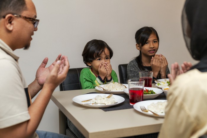 Asian Muslim saying Bismillah on table praying before opening of fast during the month of ramadan