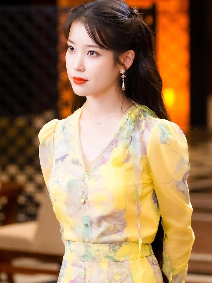 IU memerankan Jang Man Wol di Hotel del Luna. Ada banyak dress yang digunakan karakter ini sepanjang musim drakor tersebut, salah satunya berwarna kuning.