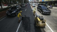 Petugas dari Suku Dinas Bina Marga Jakarta Utara memperbaiki Jalan Boulevard Raya, Jakarta Utara, yang rusak, Jumat (17/3/2023).