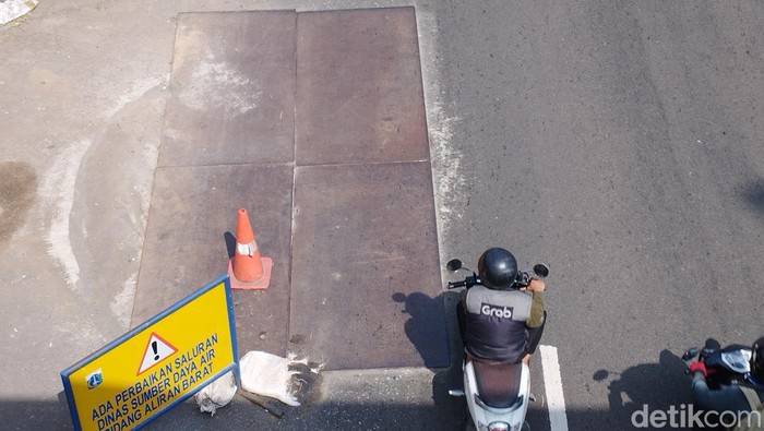 Lubang besar di Jalan Daan Mogot sudah ditambal dan ditutup pelat besi. (Brigitta Belia Permata Sari/detikcom)