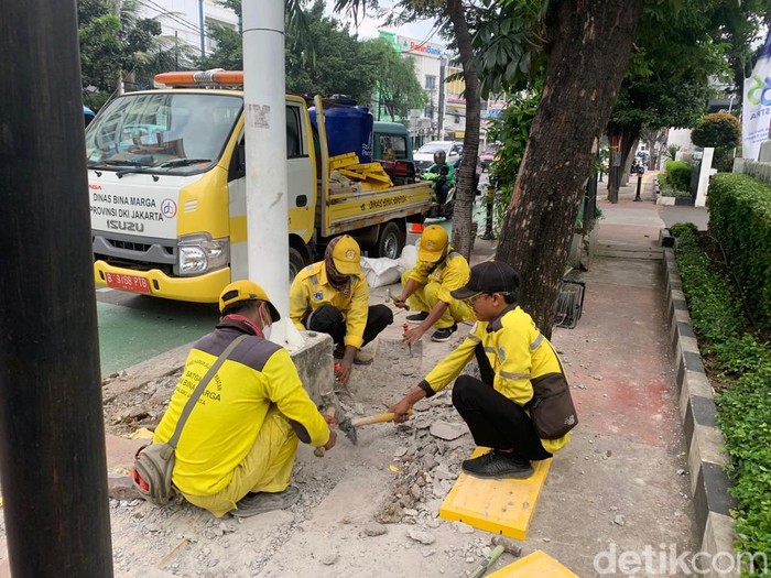 Pasukan Kuning Dinas Bina Marga DKI memperbaiki guiding block di depan RSUD Budhi Asih Jl Dewi Sartika, Jaktim, 17 Maret 2023. (Mulia Budi/detikcom)