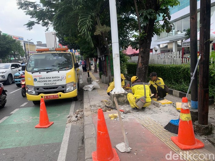 Pasukan Kuning Dinas Bina Marga DKI memperbaiki guiding block di depan RSUD Budhi Asih Jl Dewi Sartika, Jaktim, 17 Maret 2023. (Mulia Budi/detikcom)