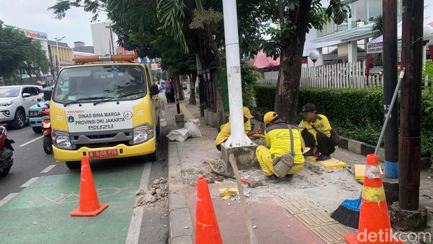 Pasukan Kuning Dinas Bina Marga DKI memperbaiki guiding block di depan RSUD Budhi Asih Jl Dewi Sartika, Jaktim, 17 Maret 2023. (Mulia Budi/detikcom)