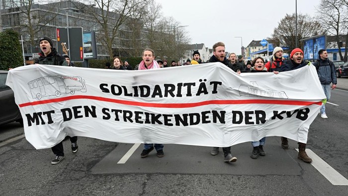 Pekerja Mogok Kerja, Bandara di Jerman Sepi Penumpang Activists of the Fridays for Future movement carry a banner as they express solidarity with the public transport sector of Cologne's public transport system KVB, before a joint rally with Germany's trade union Verdi, demanding a wage raise in the public sector, in Cologne, Germany, March 3, 2023. The banner reads: