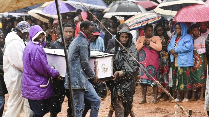 People attend the burial ceremony of some of the people who lost their lives following heavy rains caused by Cyclone Freddy in Blantyre, southern Malawi, Wednesday, March 15, 2023. After barreling through Mozambique and Malawi since late last week and killing hundreds and displacing thousands more, the cyclone is set to move away from land bringing some relief to regions who have been ravaged by torrential rain and powerful winds. AP Photo/Thoko Chikondi)