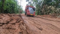 Sebuah truk melaju pelan saat melintasi Jalan Lintas Suak Kandis-Jambi yang rusak di Desa Pulau Mentaro, Muarojambi, Jambi, Kamis (16/3/2023). 