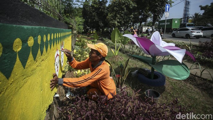 Petugas PPSU Ujung Menteng membuat mural betawi di jalan Sri Sultan Hamengkubuwono IX, Jakarta Timur, Jumat (17/3/2023).