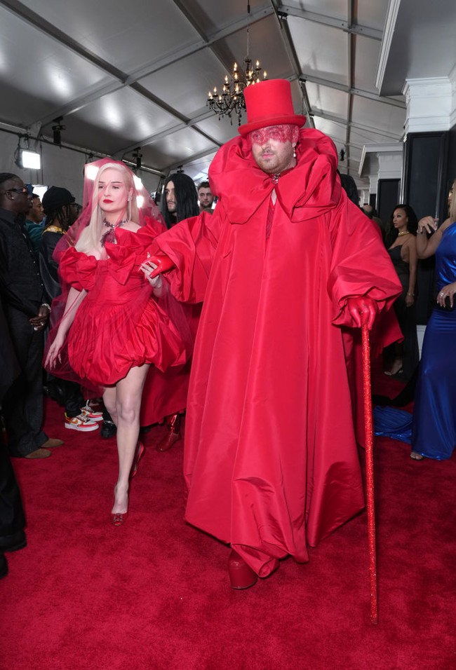 Tampil di Grammy Awards, pelantun lagu ‘Unholy’ ini mengenakan setelan halter warna merah yang dipadu jubah dengan kerah bentuk bunga dari koleksi Valentino. Sam Smith melengkapi penampilannya dengan topi panjang, penutup mata berbahan lace, sarung tangan lateks dan sepatu platform berwarna senada. Foto: Getty Images