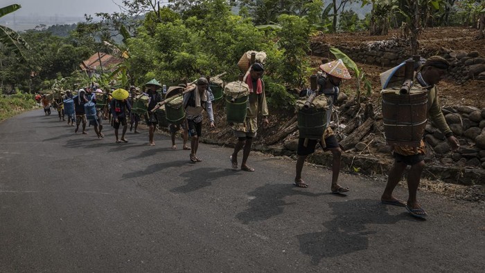 BANYUMAS, INDONESIA - MARCH 16: Bonokeling indigenous communities, walk as they carry offering of food during walk procession as part of 'Unggah-unggahan' ceremony to welcoming the Islamic holy month of Ramadan on March 16, 2023 in Banyumas, Central Java, Indonesia. Thousands of indigenous followers traveled to the Bonokeling cemetery complex, which they walked to without wearing footwear for up to 40km (25 miles) to express modesty. They carried cattle, rice, and snacks to be cooked and eaten together, in a tradition that marks the beginning of the Islamic holy month of Ramadan. (Photo by Ulet Ifansasti/Getty Images)