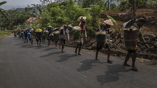 Warga kaum adat Bonokeling berjalan kaki menuju rumah adat dengan membawa hasil bumi yang merupakan bagian dari prosesi unggahan di Desa Tapen, Kecamatan Jatilawang, Banyumas, Jawa Tengah, Kamis (16/3/2023).   