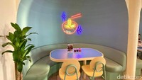 Interior kafe ini idominasi warna terang seperti biru, merah, dan hijau yang dipadukan secara kontras.