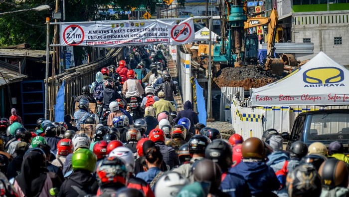 Jalan Bogor-Sukabumi yang Amblas Mulai Diperbaiki Kendaraan roda dua melintasi jembatan sementara saat adanya perbaikan ruas jalan nasional Bogor-Sukabumi yang amblas di Cikereteg, Kabupaten Bogor, Jawa Barat, Sabtu (18/3/2023). Petugas kepolisian memberlakukan sistem buka tutup pada perbaikan ruas jalan yang amblas tersebut sehingga ditargetkan bisa rampung dalam delapan bulan ke depan. ANTARA FOTO/Raisan Al Farisi/nym.
