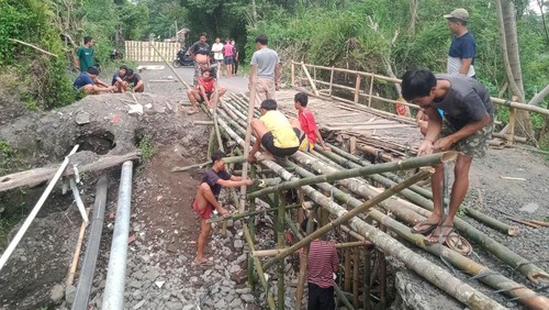 Para pemuda bersama dengan masyarakat saat membuat jembatan darurat di ruas jalan Jungutan-Tihingan agar bisa dilalui ogoh-ogoh menuju ke Bale Agung Desa Sibetan, Karangasem.