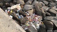 Penampakan sampah yang berserakan di atas bebatuan pinggir pantai Ancol, Jakarta ini disebabkan oleh para pengunjung yang tak mentaati aturan dalam menjaga kebersihan.
