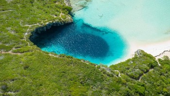 The Dean’s Blue Hole di Bahamas adalah salah satu lubang biru terdalam di dunia, mengikuti Dragon Hole. Kedalamannya mencapai 202 kaki. Di permukaan, lubang biru ini tampak melingkar, dengan lebar 80 hingga 120 kaki. Namun, begitu Anda menuruni depresi, sedalam sekitar 20 meter, lubang ini melebar hingga diameter 100 meter. Ini populer di kalangan penyelam dan merupakan tempat untuk Kompetisi Selam Bebas Vertikal tahunan. Foto: Bahamas Air Tours