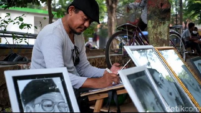Atim Adi, buruh pabrik pelukis sketsa wajah di Alun-alun Kota Probolinggo.