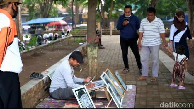 Atim Adi, buruh pabrik pelukis sketsa wajah di Alun-alun Kota Probolinggo.