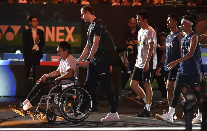 Mohammad Ahsan attends the podium in a wheelchair after an injury during the mens double final match against Indonesias Indonesias Fajar Alfian and Muhammad Rian Ardinanto in the All England Open Badminton Championships at the Utilita Arena in Birmingham, England, Sunday, March 19, 2023. (AP Photo/Rui Vieira)