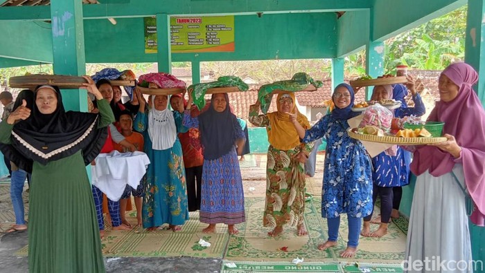 Ibu-ibu warga Desa Tulas, Kecamatan Karangdowo membawa makanan di bangsal makam, Minggu (19/3/2023).