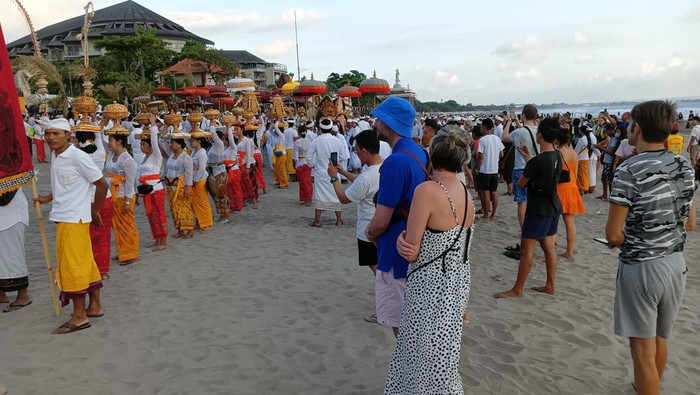 Sejumlah wisatawan antusias menyaksikan proses upacara Melasti di Seminyak, Badung, Minggu (19/3/2023).