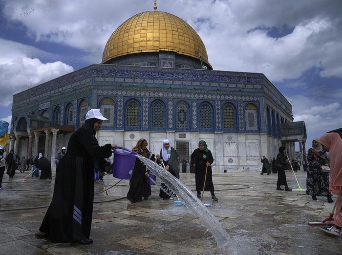Palestinian volunteers clean the ground outside the Dome of Rock Mosque at the Al-Aqsa Mosque compound ahead of the Muslims holy month of Ramadan, in Jerusalem's Old City, Saturday, March 18, 2023. (AP Photo/Mahmoud Illean)