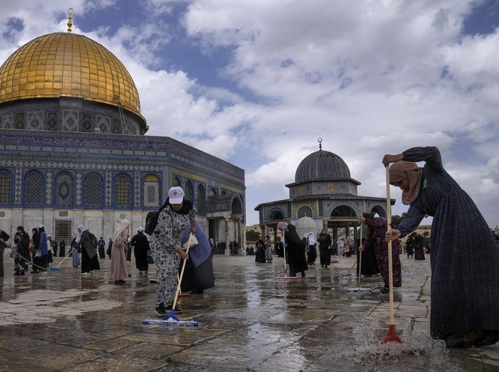 Palestinian volunteers clean the ground outside the Dome of Rock Mosque at the Al-Aqsa Mosque compound ahead of the Muslims holy month of Ramadan, in Jerusalem's Old City, Saturday, March 18, 2023. (AP Photo/Mahmoud Illean)