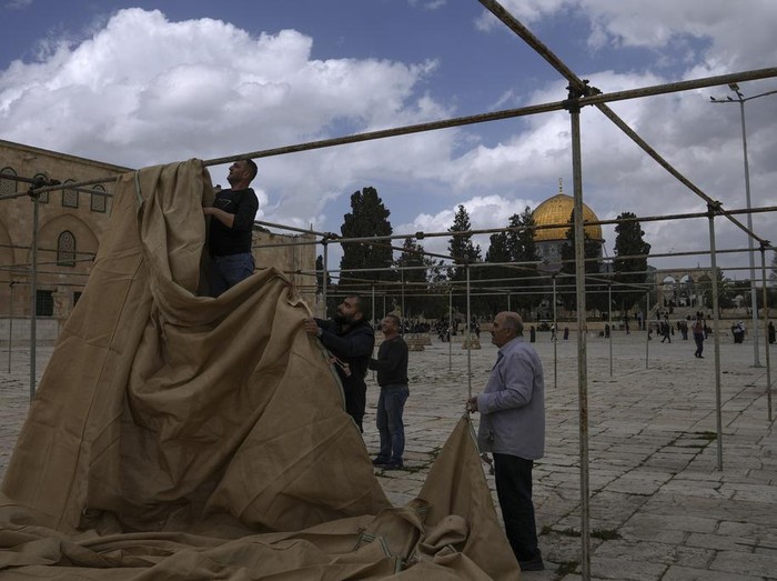 Palestinian volunteers set up sunshades at the Al-Aqsa Mosque compound in preparation for the upcoming Muslims holy month of Ramadan, in Jerusalem's Old City, Saturday, March 18, 2023. (AP Photo/Mahmoud Illean)
