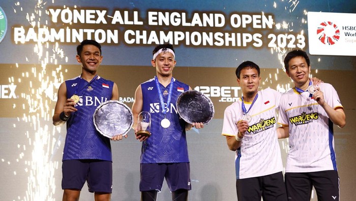 Badminton - All England Open Badminton Championships - Utilita Arena, Birmingham, Britain - March 19, 2023 Indonesias Fajar Alfian and Muhammad Rian Ardianto celebrate on the podium after winning the mens doubles final along with runners-up Indonesias Mohammad Ahsan and Hendra Setiawan Action Images via Reuters/Andrew Boyers