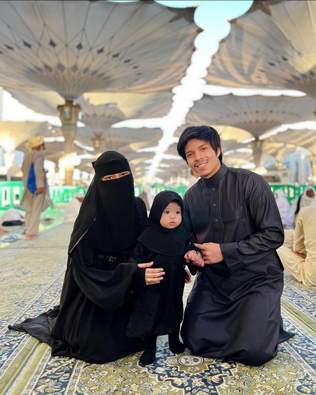 Beribadah di Masjid Nabawi, Madinah, Aurel Hermansyah memakai busana hitam-hitam. Ia tampak mengenakan cadar yang menutupi wajahnya. Anak Anang Hermansyah ini pun tampil kompak dengan suami dan putrinya yang juga berbusana hitam. Foto: Instagram/@aurelie.hermansyah