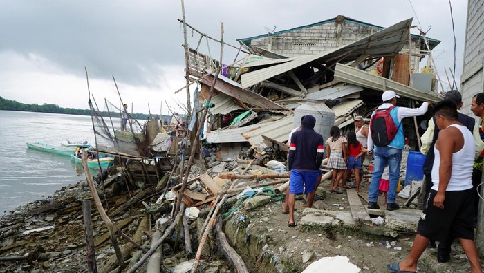 Begini Dampak Gempa M 6,8 di Ekuador People look at a destroyed house following an earthquake in Isla Puna, Ecuador, March 19, 2023. REUTERS/Maria Fernanda Landin REFILE - QUALITY REPEAT