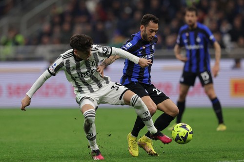 MILAN, ITALY - MARCH 19: Hakan Calhanoglu of FC Internazionale and Matias Soule Malvano of Juventus FC battle for the ball during the Serie A match between FC Internazionale and Juventus at Stadio Giuseppe Meazza on March 19, 2023 in Milan, Italy. (Photo by Francesco Scaccianoce/Getty Images)
