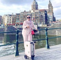 Tas Hermes juga menjadi pilihan istri Sekda Riau saat berpose liburan di luar negeri sambil menenteng koper. Adrias tampak memakai Hermes Lindy berwarna pink yang harganya lebih dari Rp 100 juta. Foto: Dok. Instagram, Twitter