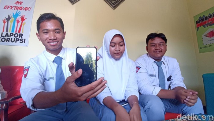 Muhzin menunjukkan handphone baru hadiah dari teman-temannya MAN 1 Kota Blitar