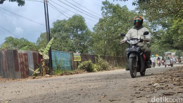 Penampakan Jalan Poros Pattalassang, Gowa, Sulawesi Selatan (Sulsel) yang penuh debu.