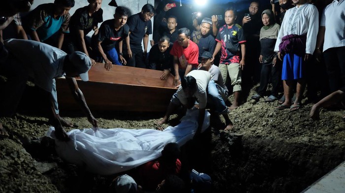 Warga menurunkan jenazah pebulutangkis tunggal putra Pelatnas CIpayung, Syabda Perkasa Belawa ke liang lahat saat permakaman di Dukuh Karaban, Desan Sumber Rejo, Kecamatan Mondokan, Sragen, Jawa Tengah, Senin (20/3/2023). Syabda bersama ibunya Anik Susilowati meninggal dunia dalam kecelakaan di jalan tol Pemalang, Jawa Tengah, Senin (20/3/2023) dini hari. ANTARAFOTO/Maulana Surya/nym.