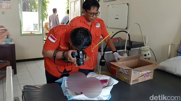 Polisi memeriksa  jenazah bayi yag ditemukan di Tulungagung
