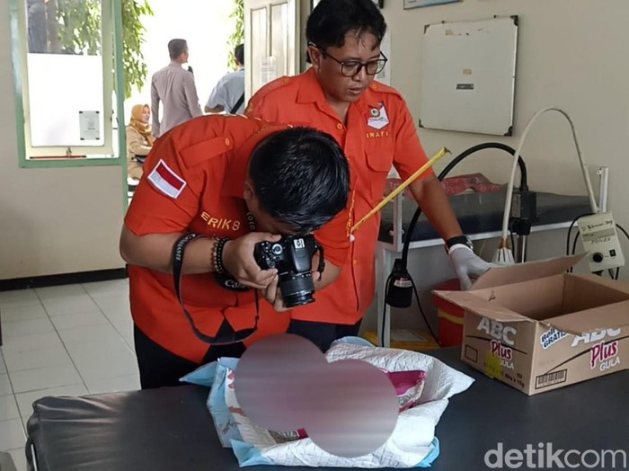 Polisi memeriksa  jenazah bayi yag ditemukan di Tulungagung