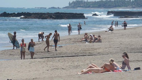 Turis asing berjemur dan menikmati deburan ombak Pantai Batu Bolong di Desa Canggu, Kecamatan Kuta Utara, Badung, beberapa waktu lalu. (Agus Eka)