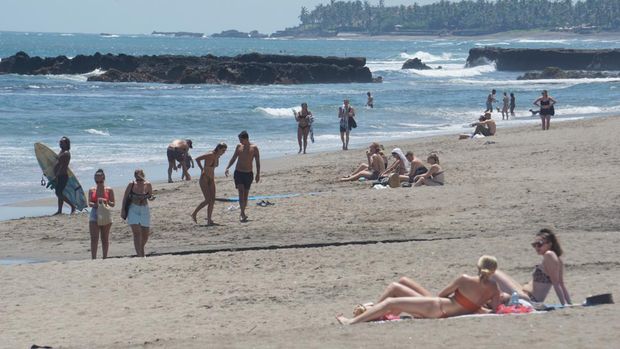 Turis asing berjemur dan menikmati deburan ombak Pantai Batu Bolong di Desa Canggu, Kecamatan Kuta Utara, Badung, beberapa waktu lalu. (Agus Eka)
