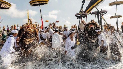 CANGGU, BALI, INDONESIA - MARCH 19: Balinese Hindus woman in a state of trance, screams during Melasti Ritual prior to Nyepi Day on March 19, 2023 at Batubolong Beach, in Canggu Bali, Indonesia. After three years of performing purification ceremony ahead of Nyepi Day on a small scale due to the COVID-19 pandemic Balinese Hindus dressed in predominantly white attire carried sacred effigies of gods and goddesses and ritual paraphernalia from their village temples to the beach to perform a purification ceremony called the Melasti ritual. Balinese Hindus believe the Melasti ritual is a must perform ahead of Nyepi Day, The Day of Silence, to cleanse the soul and nature, recharge the supernatural power of the temples sacred objects and cleanse the temple paraphernalia. The Nyepi Day is a national holiday in Indonesia and is a day for self-reflection and abstaining from distractions such as entertainment. (Photo by Agung Parameswara/Getty Images)