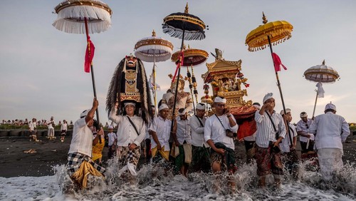 CANGGU, BALI, INDONESIA - MARCH 19:  Balinese Hindus woman in a state of trance, screams during Melasti Ritual prior to Nyepi Day on March 19, 2023 at Batubolong Beach, in Canggu Bali, Indonesia. After three years of performing purification ceremony ahead of Nyepi Day on a small scale due to the COVID-19 pandemic Balinese Hindus dressed in predominantly white attire carried sacred effigies of gods and goddesses and ritual paraphernalia from their village temples to the beach to perform a purification ceremony called the Melasti ritual. Balinese Hindus believe the Melasti ritual is a must perform ahead of Nyepi Day, The Day of Silence, to cleanse the soul and nature, recharge the supernatural power of the temples sacred objects and cleanse the temple paraphernalia. The Nyepi Day is a national holiday in Indonesia and is a day for self-reflection and abstaining from distractions such as entertainment. (Photo by Agung Parameswara/Getty Images)