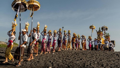 CANGGU, BALI, INDONESIA - MARCH 19:  Balinese Hindus woman in a state of trance, screams during Melasti Ritual prior to Nyepi Day on March 19, 2023 at Batubolong Beach, in Canggu Bali, Indonesia. After three years of performing purification ceremony ahead of Nyepi Day on a small scale due to the COVID-19 pandemic Balinese Hindus dressed in predominantly white attire carried sacred effigies of gods and goddesses and ritual paraphernalia from their village temples to the beach to perform a purification ceremony called the Melasti ritual. Balinese Hindus believe the Melasti ritual is a must perform ahead of Nyepi Day, The Day of Silence, to cleanse the soul and nature, recharge the supernatural power of the temples sacred objects and cleanse the temple paraphernalia. The Nyepi Day is a national holiday in Indonesia and is a day for self-reflection and abstaining from distractions such as entertainment. (Photo by Agung Parameswara/Getty Images)